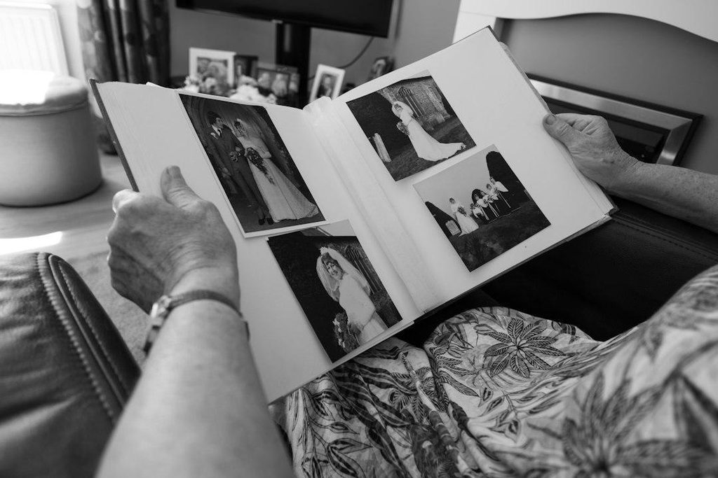 An older person looking through a family photo album